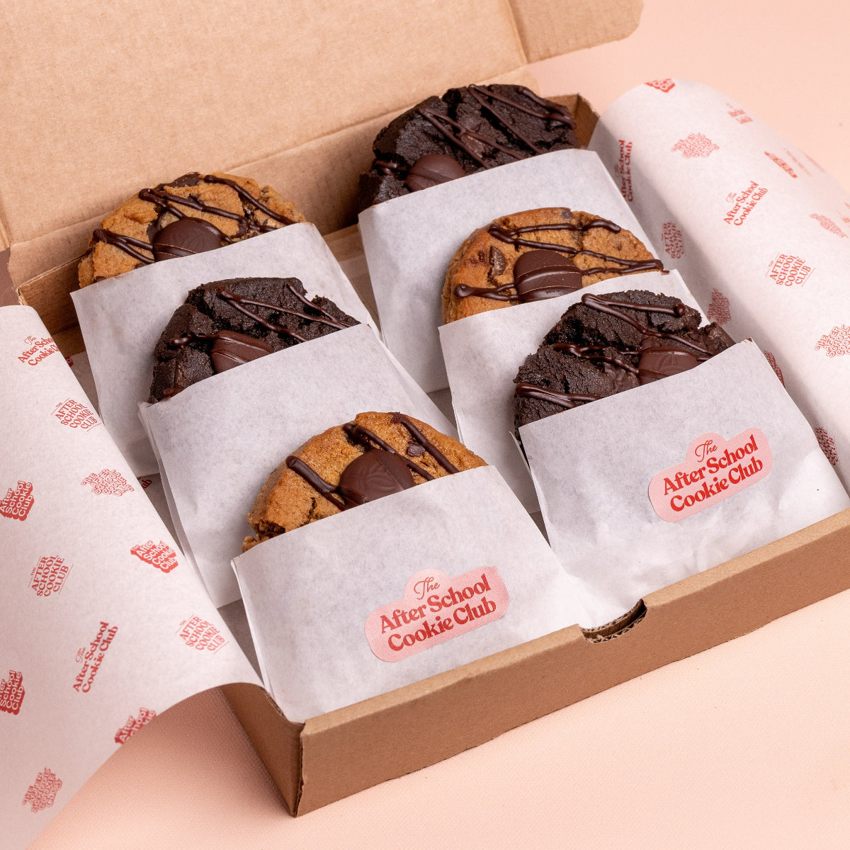Box of assorted cookies from The After School Cookie Club on a light pink background