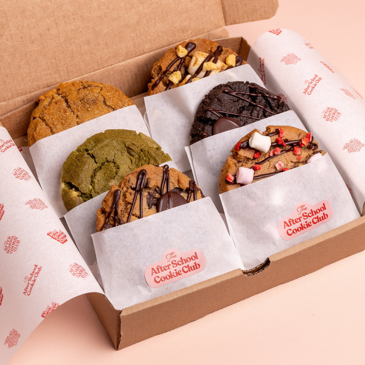 Box of assorted cookies from The After School Cookie Club on a light pink background
