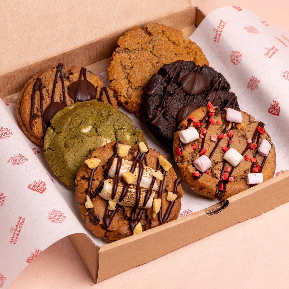 Box of assorted cookies with different toppings on a patterned paper