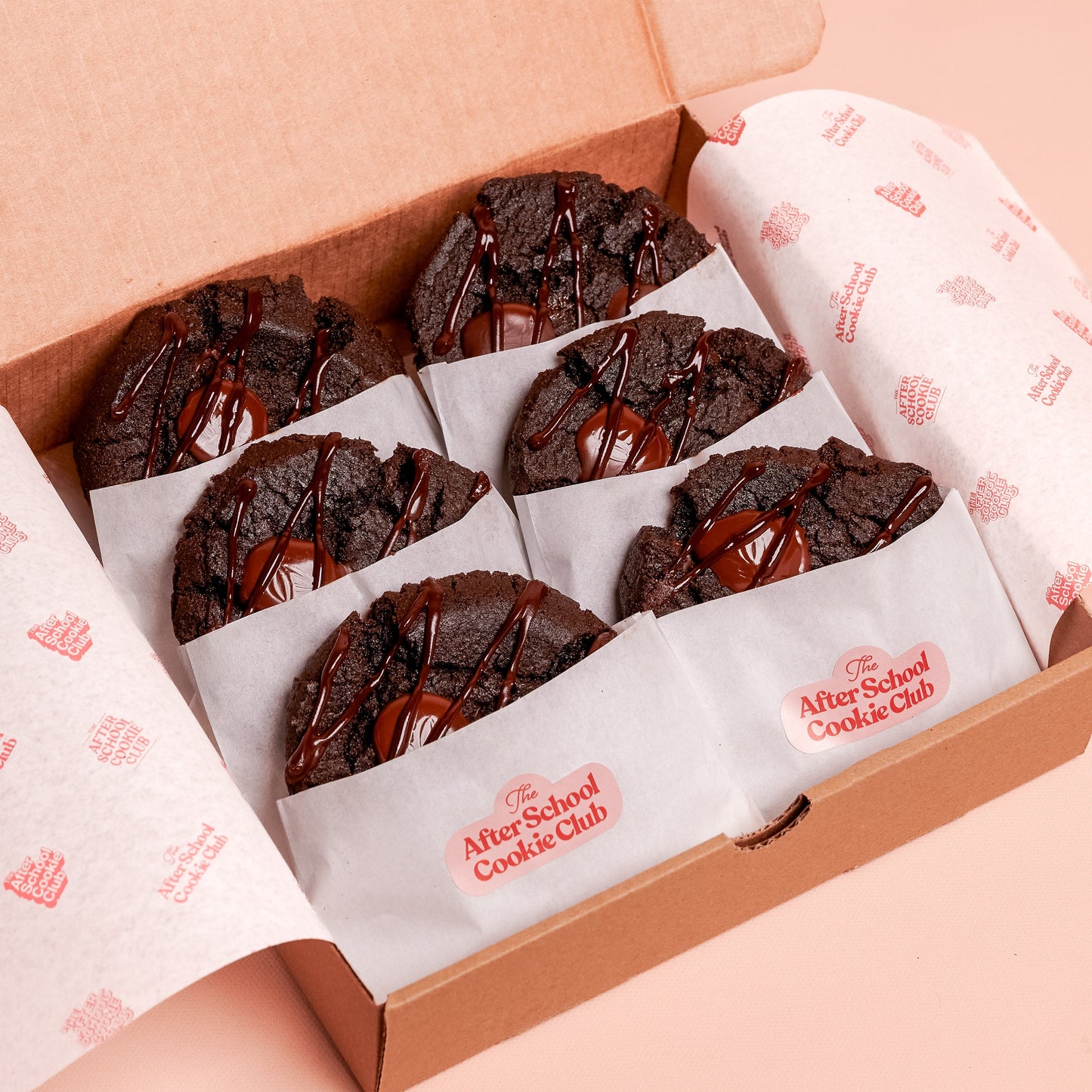 Box of double chocolate cookies on a pink background