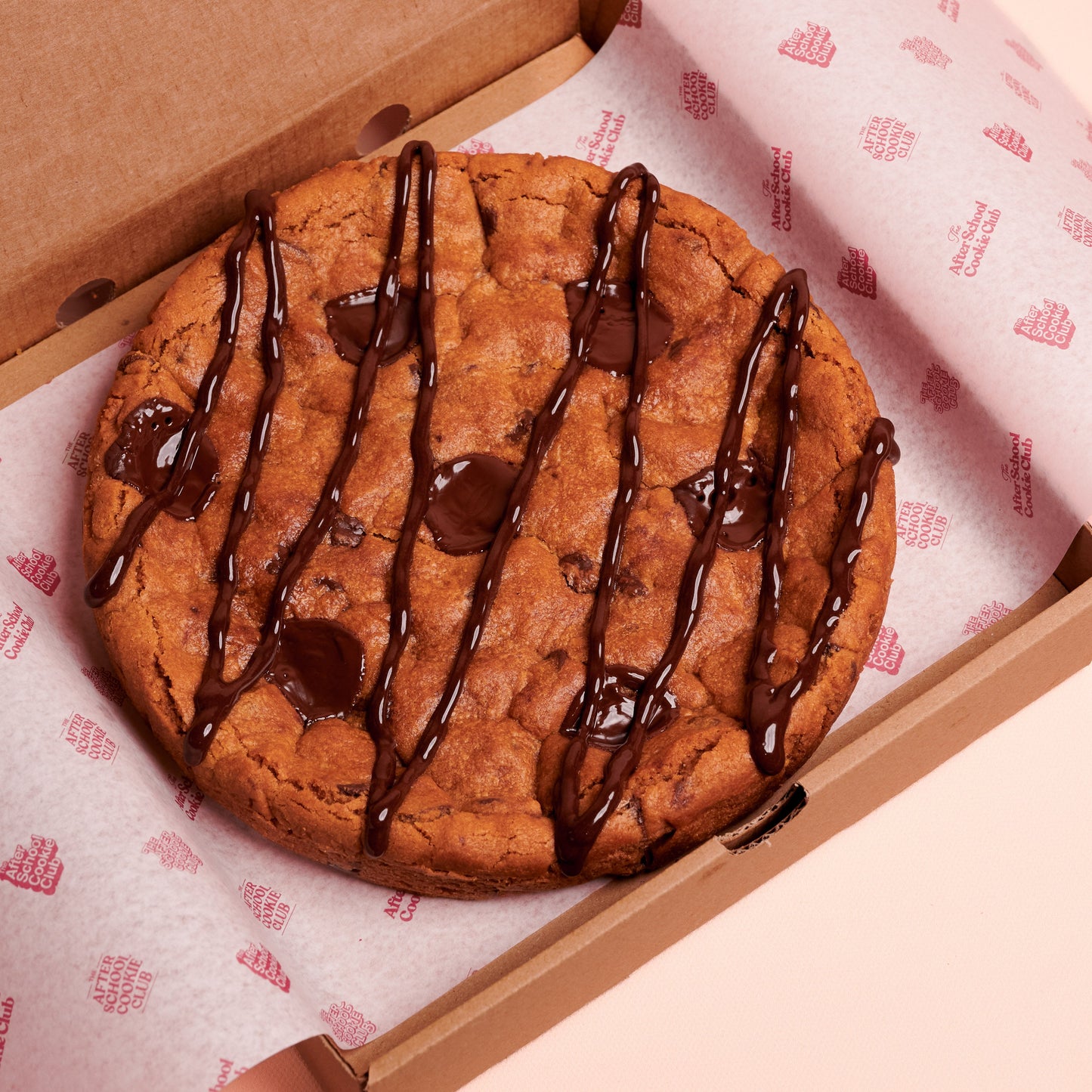 Giant Chocolate chip Cookie in a box on pink background