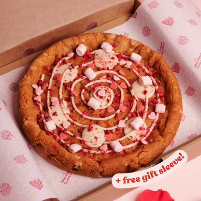 Giant White Chocolate Cookie with marshmallows and heart sprinkles on pink background